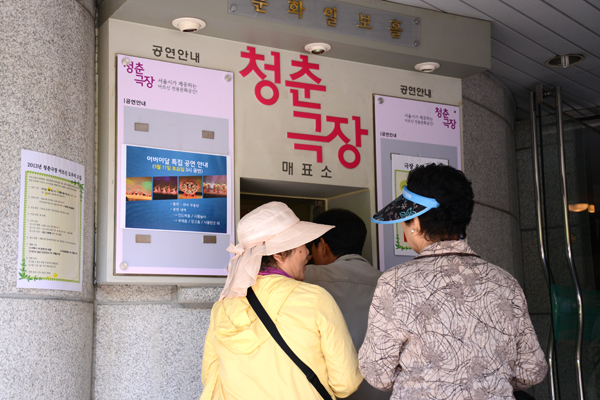 청춘극장을 방문한 어르신들이 매표소에서 표를 구매하고 있다.