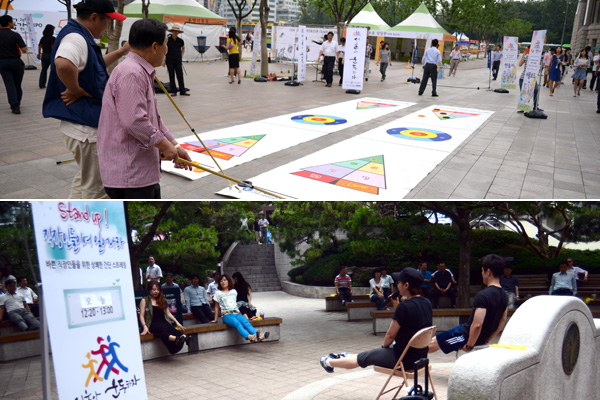 점심시간을 맞아 서울광장에서 직장인들이 셔플보드 게임과 뜨락소공원에서 힐링체조를 하고 있다.