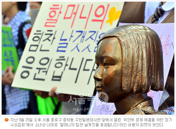 지난 9월 25일 오후 서울 종로구 중학동 주한일본대사관 앞에서 열린 '위안부 문제 해결을 위한 정기 수요집회'에서 소녀상 너머로 '할머니의 힘찬 날개짓을 응원합니다'라는 내용의 피켓이 보인다