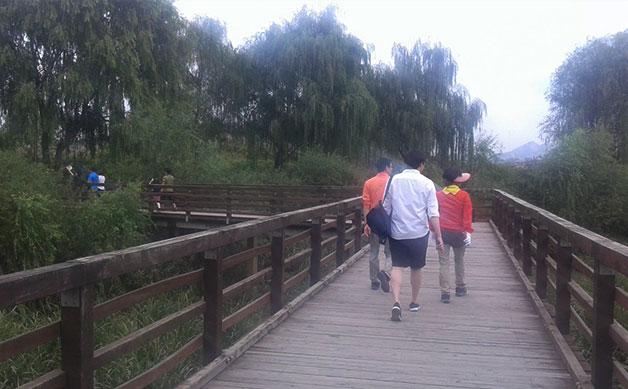 공원 내 습지 위로 설치된 목데크 탐방로를 걷고 있는 시민들