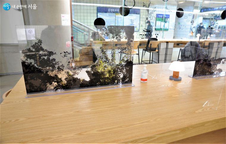 ‘LOUNGE 사이’ 테이블에 설치된 코로나19 예방용 아크릴 가림막은 중간에 자연 풍경을 넣어 안정감을 도모하였다 ⓒ조수봉