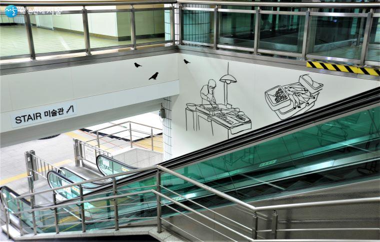 지하 1·2층을 연결하는 에스컬레이터 공간에 설치한 ‘STAIR 미술관’에는 작가 황혜선의 「시장 풍경」 세 작품이 전시되었다  ⓒ조수봉