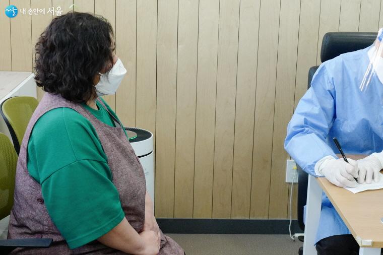 코로나 백신을 처음으로 맞는 ？황인혜 요양보호사가 예진실에서 담당 의사와 상담을 하고 있다.