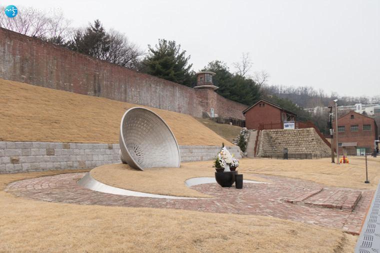 지금까지 찾아낸 순국지사 165분의 이름이 새겨진 기념비와 형무소 붉은 담과 옥사가 보인다  ⓒ김인수