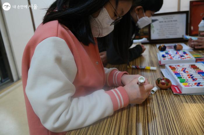 계란에 그림 그림기 행사에 참여 중인 초등학생