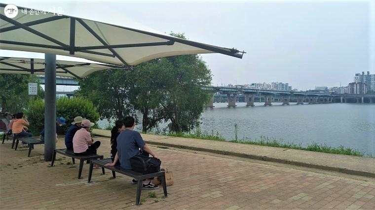 광나루한강공원에서 광진교와 한강을 바라보며 시민들이 휴식을 취하고 있다. ⓒ이봉덕