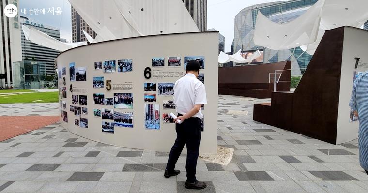 한 시민이 서울시의회 부활 30주년 사진전을 관람하고 있다. 