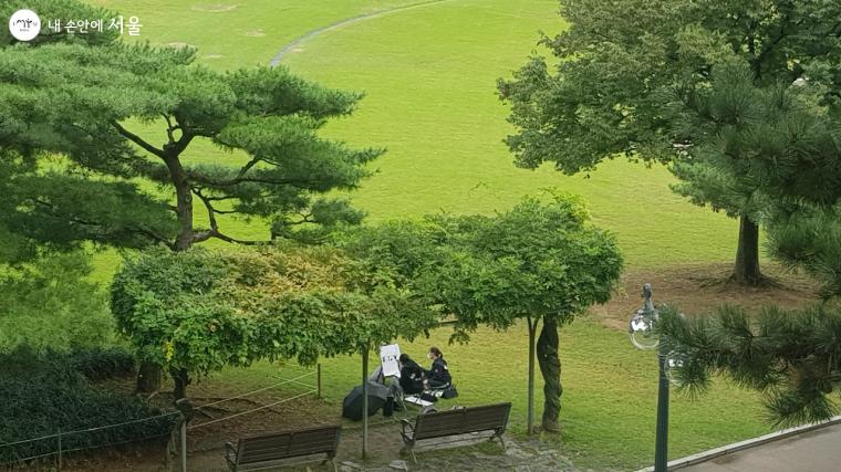 88잔디마당에 앉아서 학생들이 공원의 풍경을 화폭에 담고 있다. 