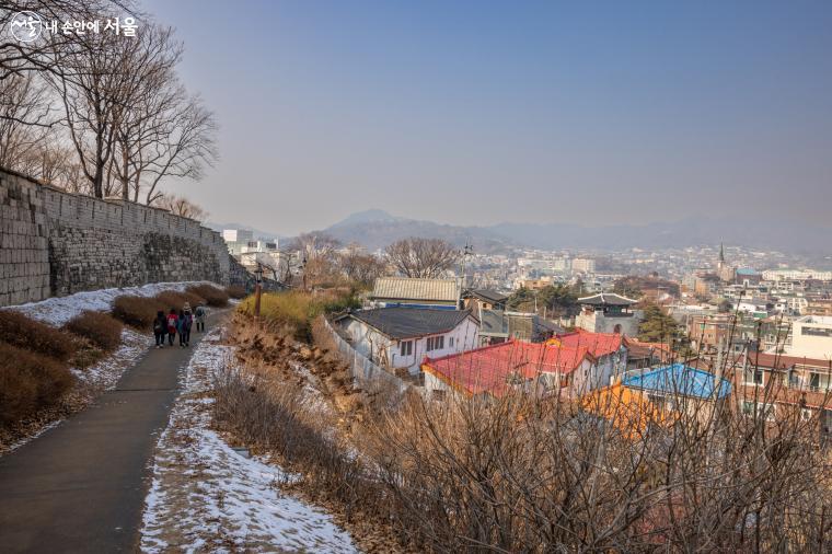 낙산 구간이 끝나는 부근 빼곡한 집들 사이로 전통 한옥 지붕을 한 건물이 혜화문이 보인다 ⓒ양인억