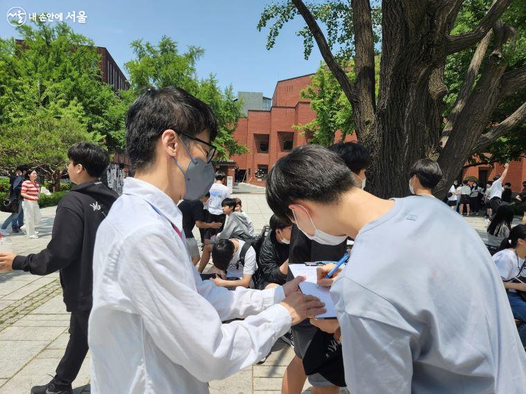 김범중 씨가 학생에게 캠페인 지지 서명을 받고 있다. ⓒ윤혜숙