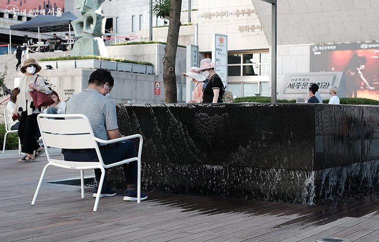 문화 쉼터에 있는 '샘물 탁자' 앞에 앉아 쉬고 있는 시민들 ⓒ김아름