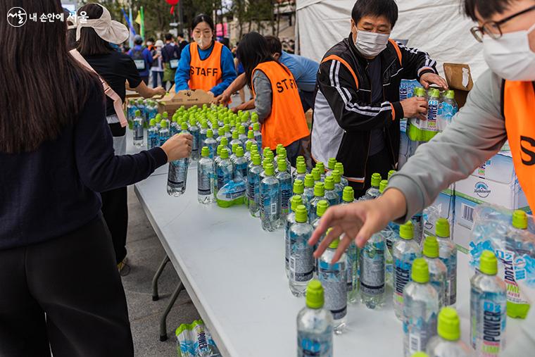 페스티벌에 참가한 걷기 완주자들에게 음료를 나눠주고 있다.