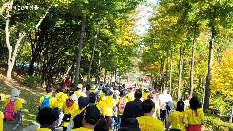 노랗게 물든 가을의 서서울호수공원을 '공항길 걷기대회' 참가자들이 지나가고 있다.      
