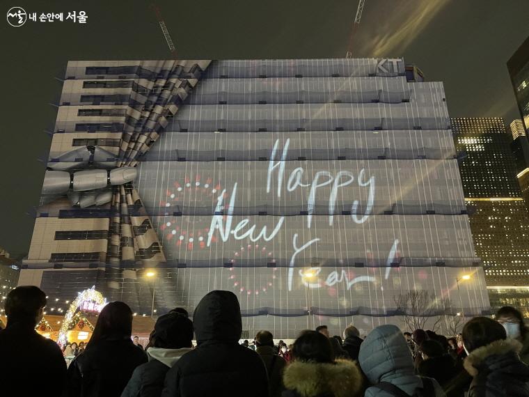 KT빌딩 가림막에 뜬 새해 인사가 나오자 시민들의 탄성이 들린다.