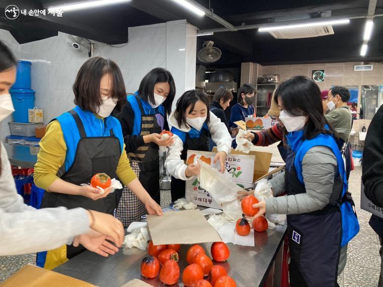 폐우산 원단으로 만든 앞치마를 두르고 배식 준비를 하는 자원봉사센터 및 큐클리프 직원들 