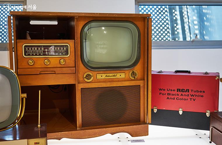 'TV: 부의 상징' 섹션에 전시된 패커드 벨사의 텔레비전(1958년). 대형 화면과 스피커, 전축, 라디오가 한 세트로 되어 있고 도어가 달려 있어 가구로서의 장식성이 두드러진다. ⓒ이정규
