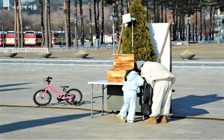 소원 메달 만들기를 하고 있는 산책 나온 모녀의 모습 ⓒ조수봉