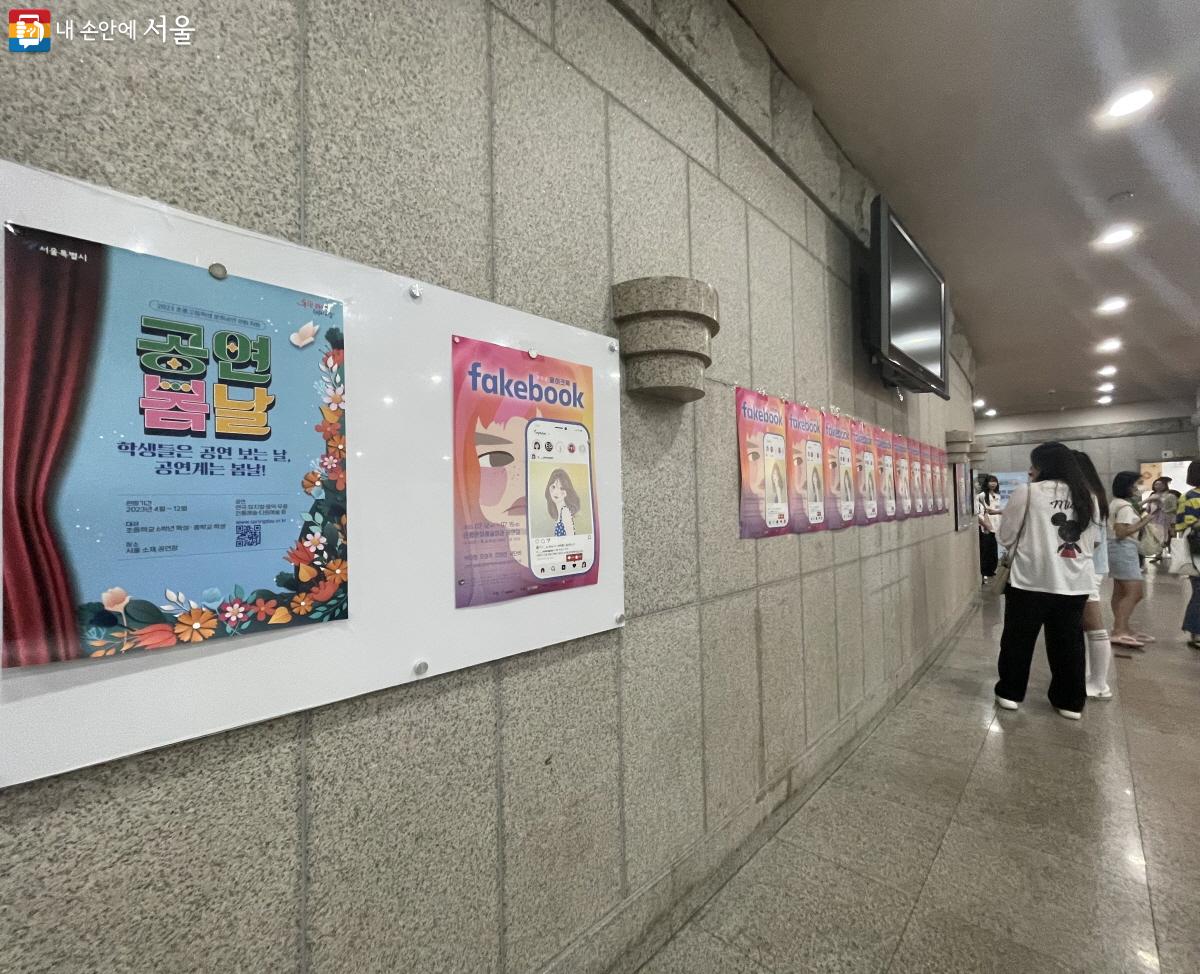 공연이 시작되기 전, 관객들이 청소년 뮤지컬 <페이크 북> 포스터를 보고 있다. ©이정민