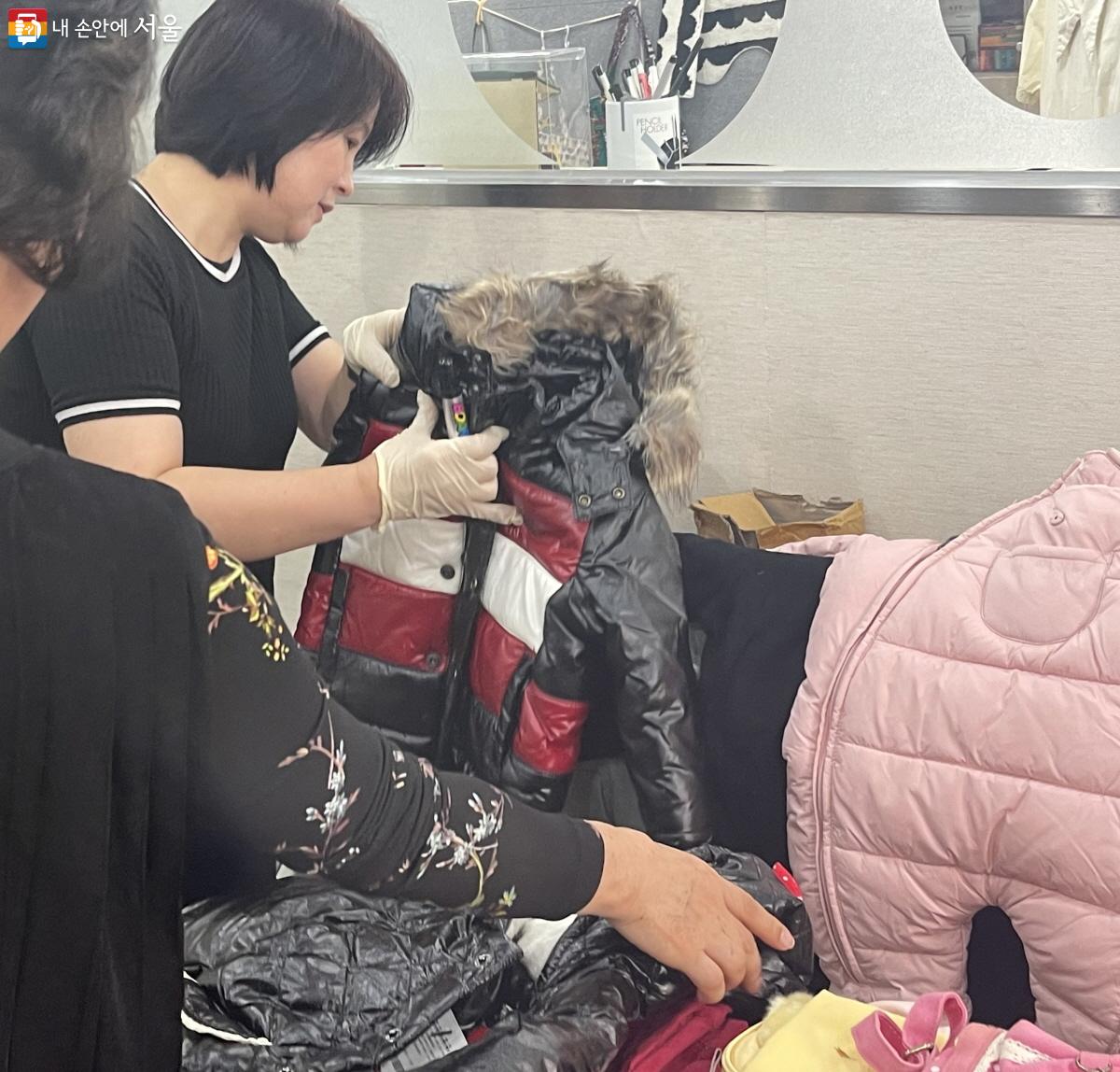 벼룩시장에 진열된 옷들을 정리하는 황향화 센터장 ©이정민