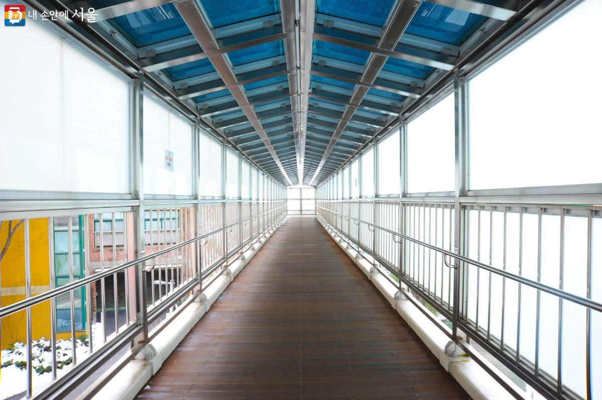 아파트 단지와 금동초등학교를 이어주는 옥외 수직형 엘리베이터를 타기 위해 설치된 길이 56m의 보행교 ⓒ조수봉