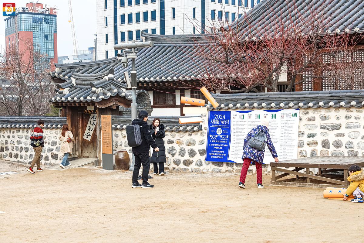 '새해 윷점' 코너에서 윷을 던져보는 가족 방문객의 모습 ©박우영