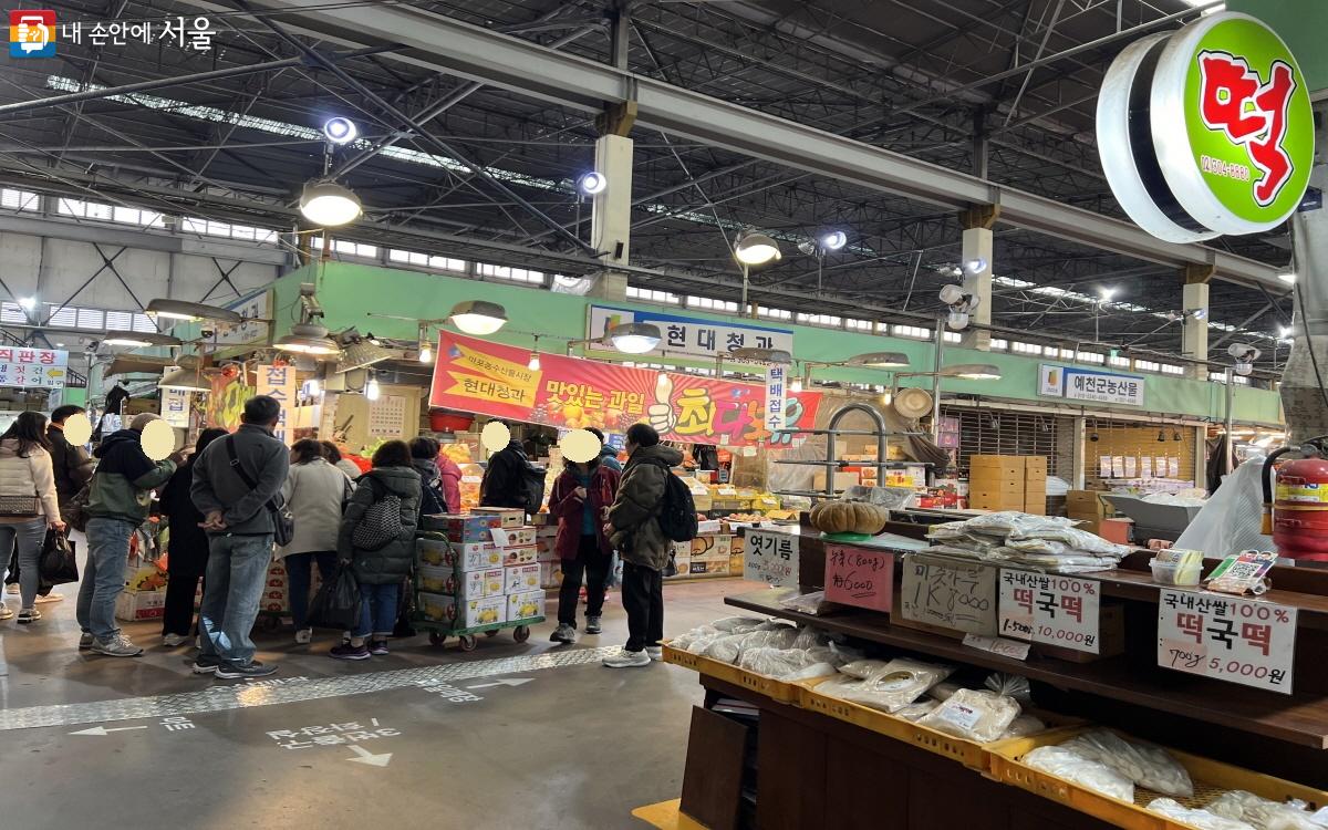 시장에서 과일을 구매하고 있는 외국인 단체 관광객들©박지영
