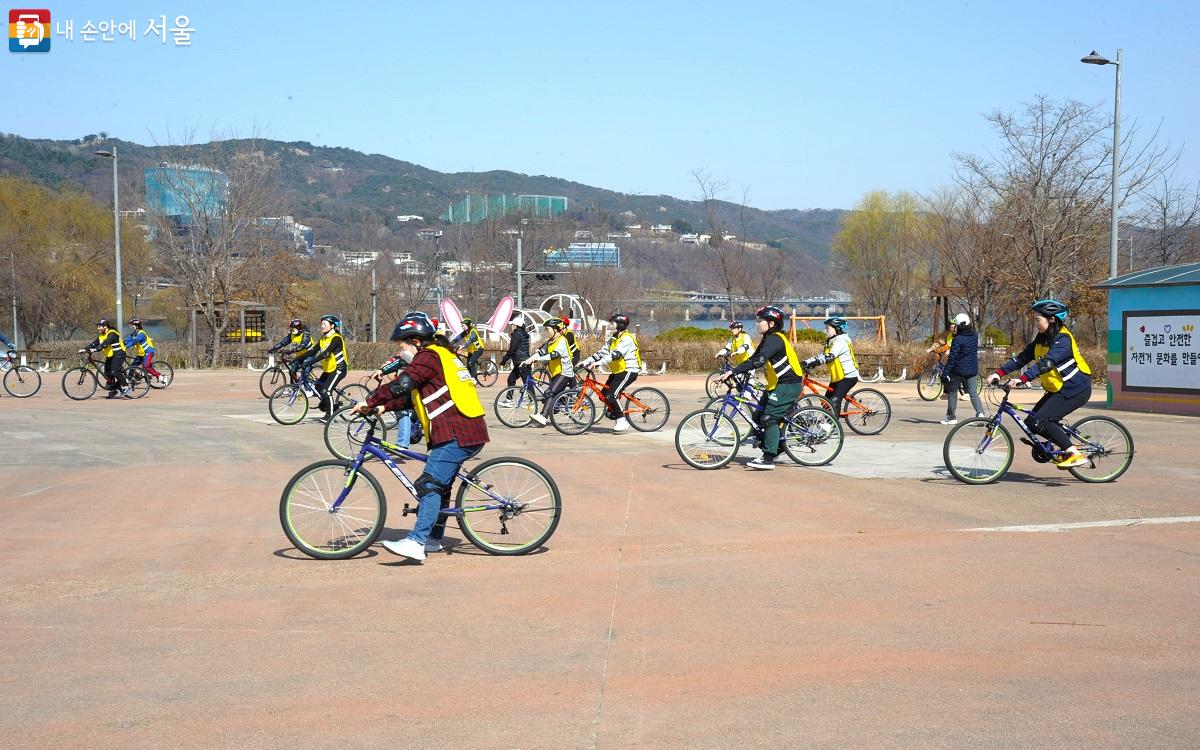 자전거 안장에 앉아 두 발로 땅바닥을 밀고 가는 ‘중심 잡기’ 실습을 하는 수강생들 ⓒ조수봉