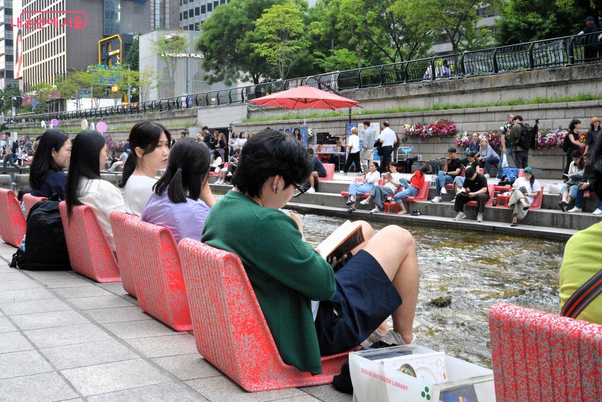 맑은 냇가에 앉아 책 읽기에 몰두하는 시민들의 모습이 인상적이다. ©이봉덕