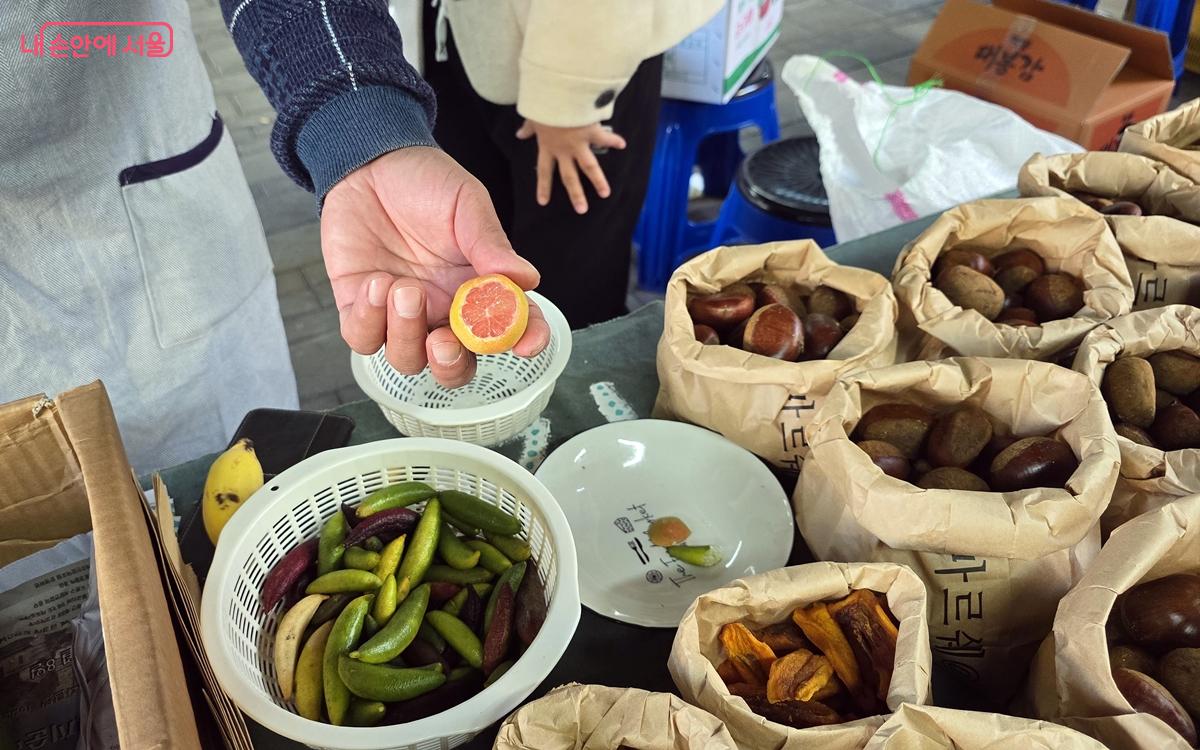 상인이 오렌지색 라임을 보여주고 있다. ©김윤경