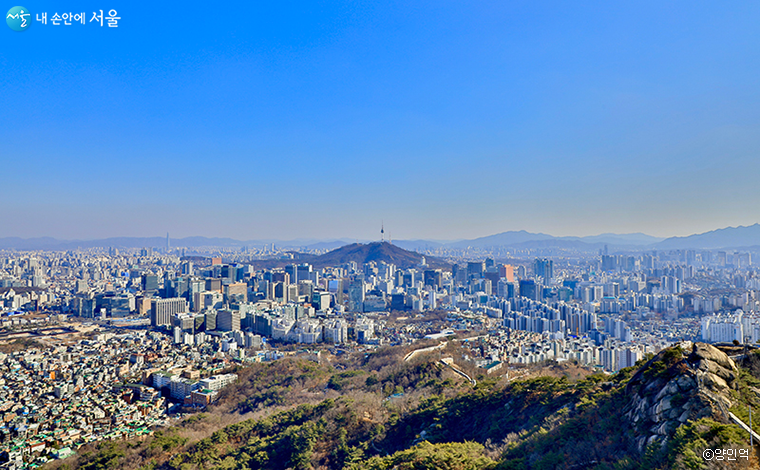 인왕산 능선을 따라 물결치듯 굽어지는 성곽과 N서울타워 그 사이로 무수히 많은 서울의 빌딩들