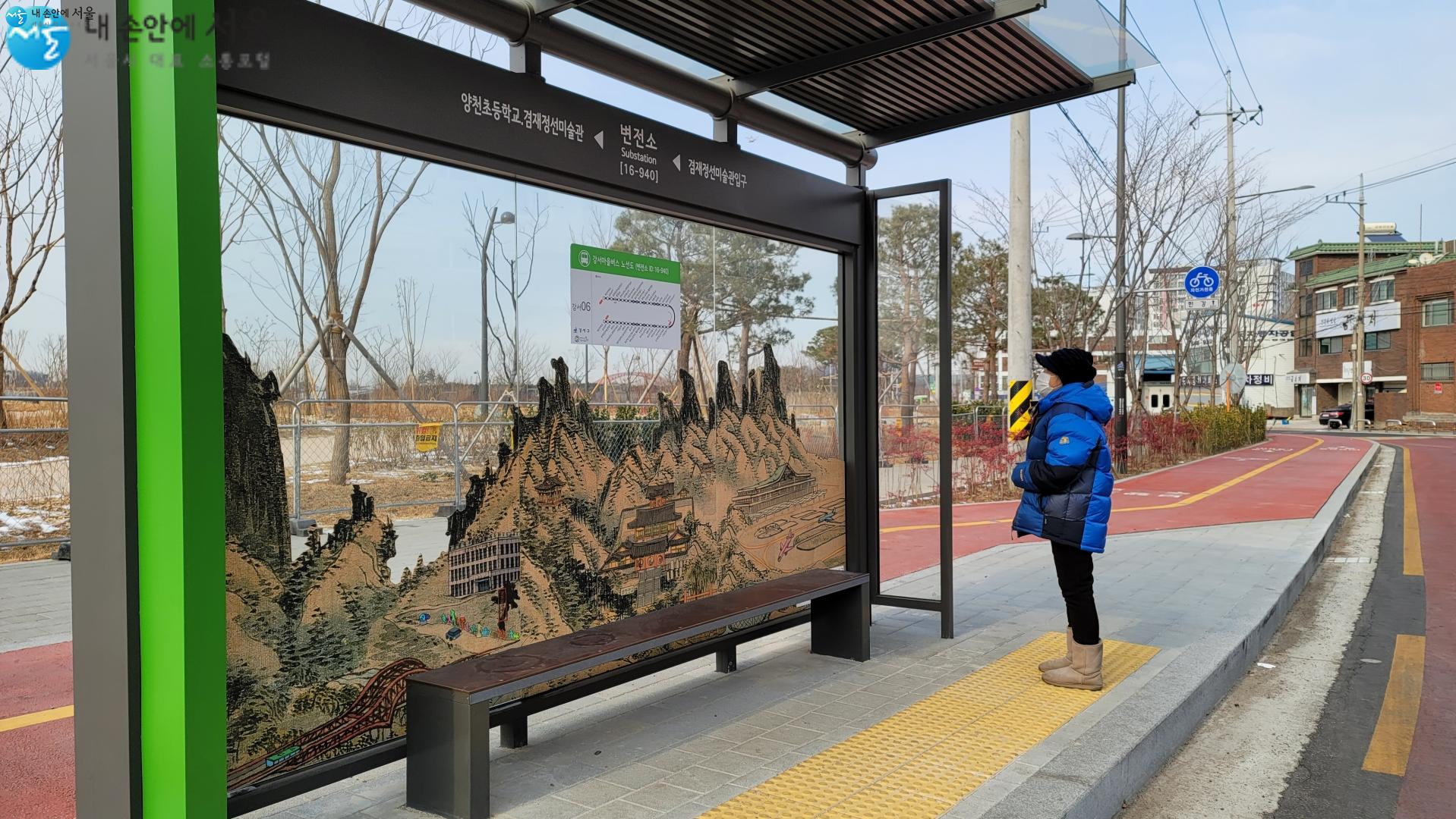 새롭게 조성한 겸재정선미술관 버스정류장에서 한 시민이 산수화를 가미한 작품을 바라보고 있다.