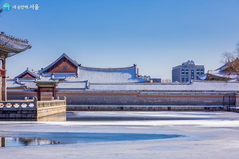 경회루 서쪽에서 바라본 강녕전 일원. 경회루로 통하는 자시문 뒤로 왕의 내전인 강녕전의 붉은색 측면 지붕이 보인다. 서쪽을 향한 지붕에 소복이 쌓인 눈이 경복궁의 아름다운 겨울 모습을 보여주고 있다 ⓒ양인억