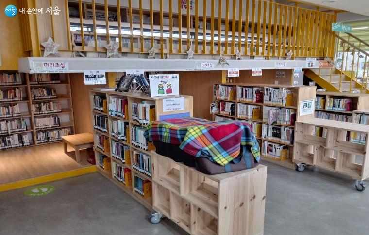도서관 내부에 책이 가지런히 진열된 모습, 2층에 다락방 독서공간이 있다.