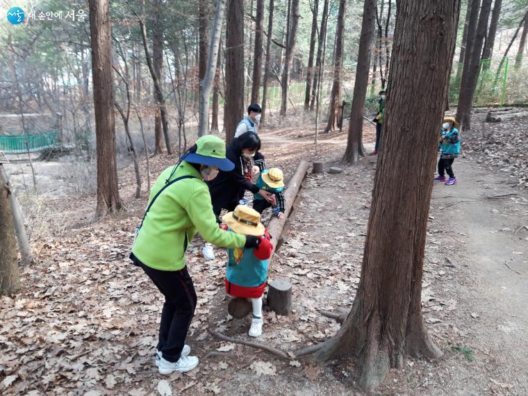 아이들이 숲길을 걸으며 담력을 기르는 활동을 하고 있다. 