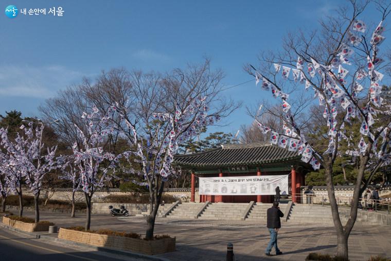 효창공원 정문(창열문)과 그 앞에 가로수를 활용 ‘태극기 트리’를 28주 설치해 태극기 꽃이 핀듯하다. 창열문 좌우 화단에는 바람개비 태극기 100여개가 돌고 있다  Ⓒ김인수
