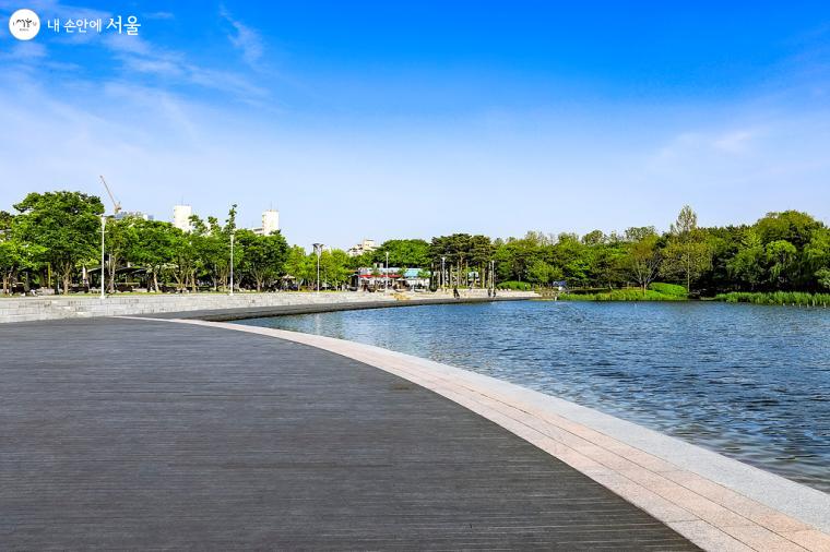 유니세프 광장을 따라 조성된 넓은 난지 연못 주변에 수변 산책로가 보인다. 