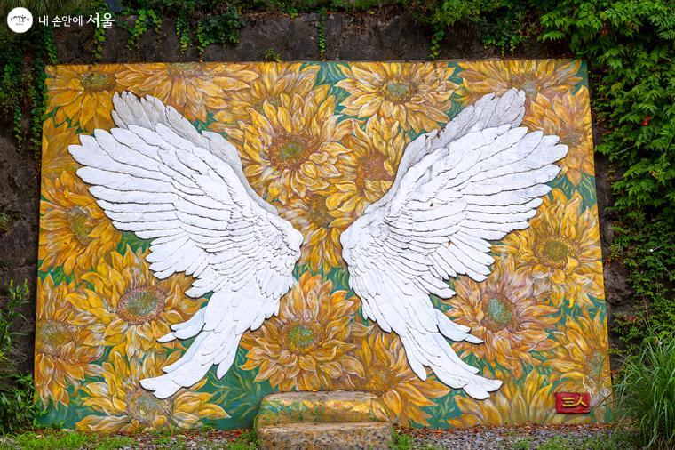 벽화 사랑의 날개-구본준 작가의 시멘트 부조 위에 김혜진 작가가 단청으로 채색한 국내 최대 규모의 날개 부조 작품이다. 나비의 날개 형상은 나비가 소리 없이 꽃에 날아오듯이 사랑도 소리 없이 곁에 온다는 것을 표현하였다 ⓒ문청야