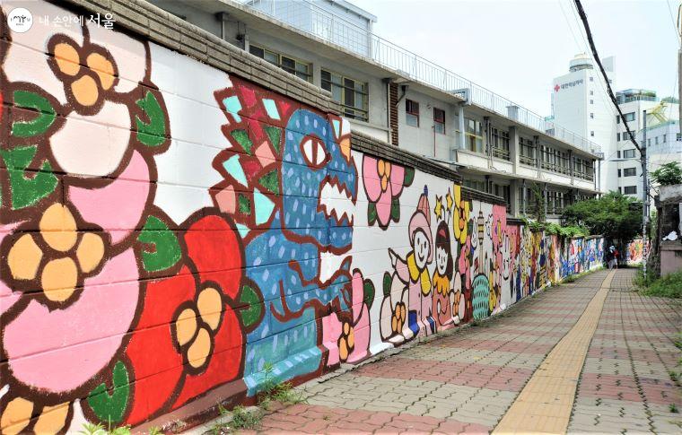 ‘명동하늘계단’ 위의 초등학교 담장 전체가 그림 전시장이 되었다 ⓒ조수봉