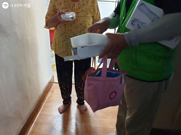 자원봉사자가 독거 어르신댁을 방문해 '얼음땡' 물품을 드리며 안부를 살피고 있다. 