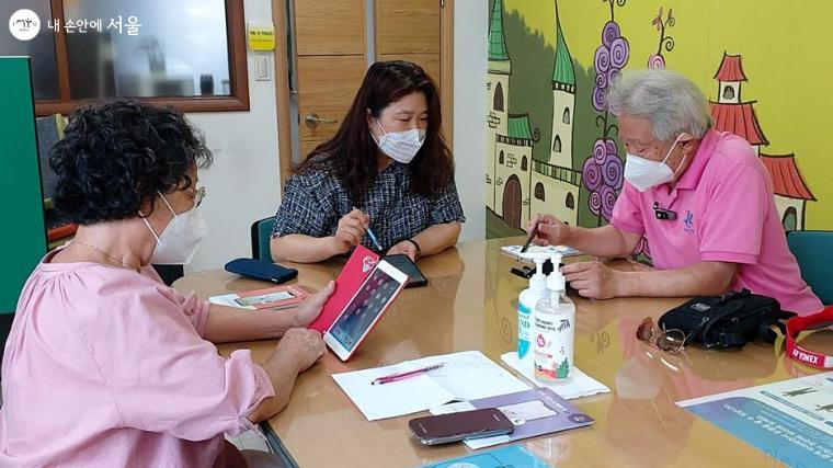 정릉실버복지센터 김수현 강사가 부부 학습자를 대상으로 스마트폰 교육을 하고 있다. 