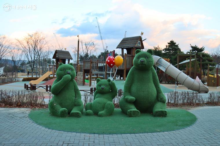 곰 가족 조형물이 야외 정원에 설치되어 있다 