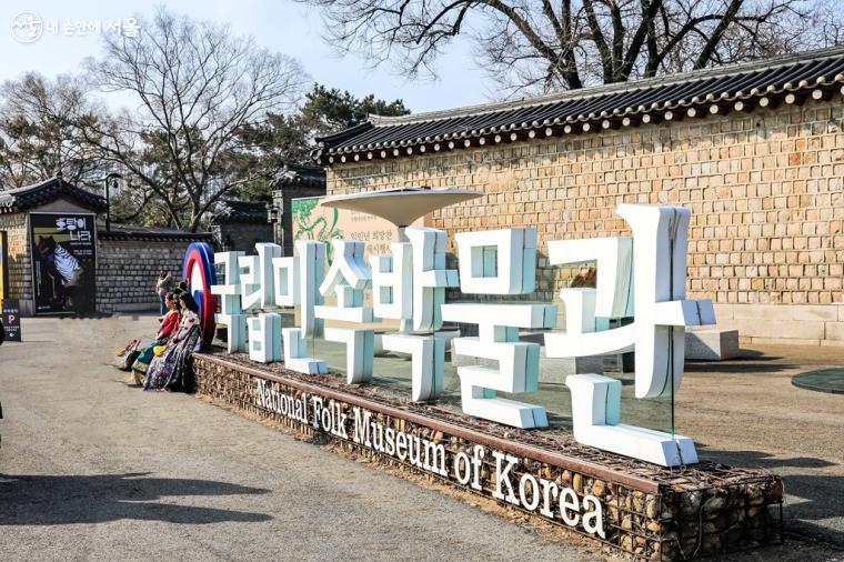 경복궁 내에 위치한 국립민속박물관 입구. 박물관을 배경으로 한복을 차려입은 시민들이 기념 사진을 찍고 있다. 