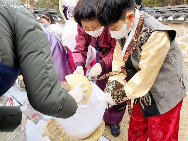 진재순 씨가 손자와 함께 소금물 내리기를 체험하고 있다.