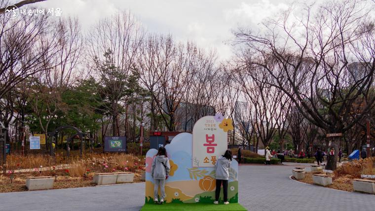 공원 입구에서 아이들이 봄소풍 인증샷을 찍으며 즐겁게 놀고 있다 ？오세훈