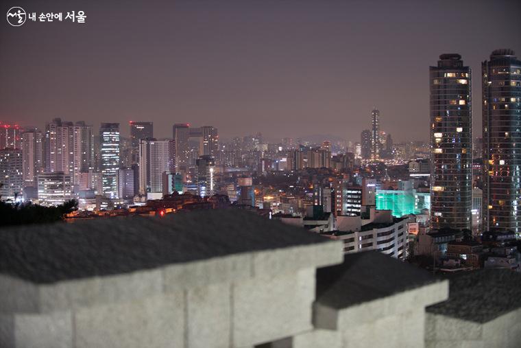  한양도성(남산구간) 여장(성벽의 제일높은 돌) 너머 야간  풍경이 아름답다.