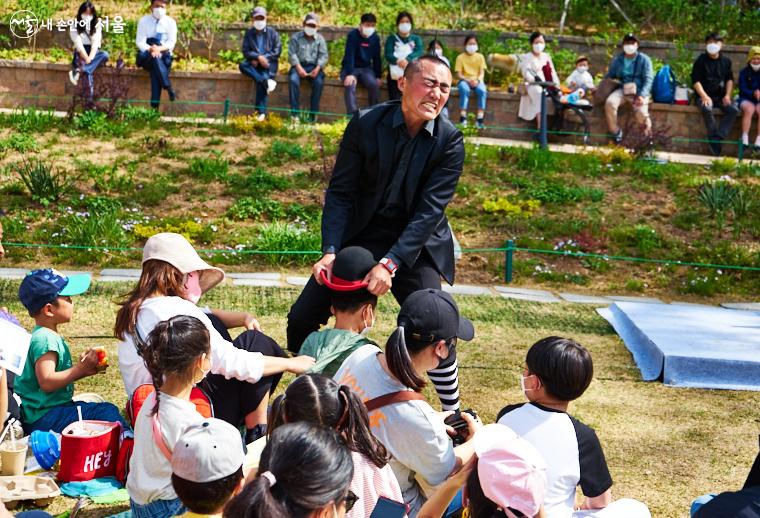 꼬마 관객 머리에 씌운 모자를 힘겹게 벗겨내는 익살스러운 표정의 ‘블랙클라운’. 관객들은 웃음보를 터뜨렸다 ⓒ이정규