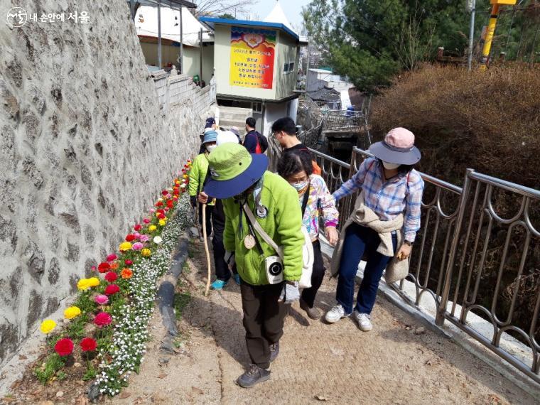 숲길 입구 가로변 꽃을 관찰하는 모습