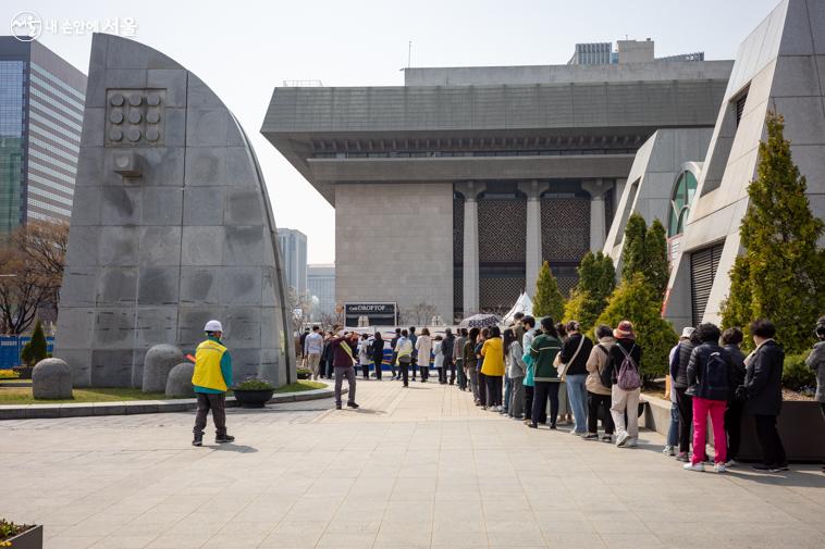 선착순 무료 분양으로 세종로공원 뒷편까지 긴 대기줄이 생겼다. 진행요원이 배치되어 안내를 돕고 있다. 