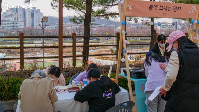 도서문화체험부스 중 한 곳에서 봄에 보내는 편지를 쓰고 있는 참가자들의 모습이 사뭇 진지해보인다.