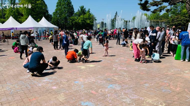 어린이날 기념 행사의 일환으로 아이들이 분필로 바닥에 그림을 그리고 있다. ？김수정   